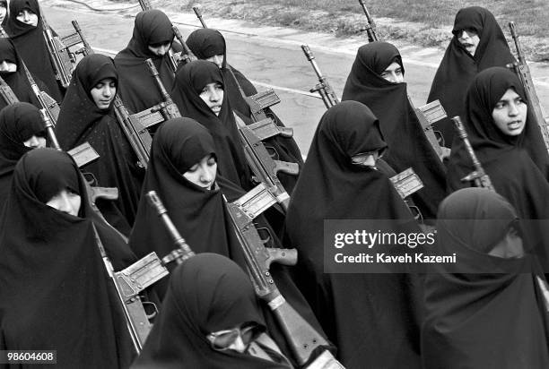 Basiji women in black chador march while carrying G-3 automatic assault rifles in a Tehran rally, 12th February 1987, towards the end of the eight...