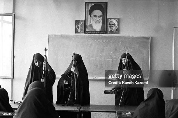 Basiji women in black chador go through arms training with Kalashinkov automatic assault rifles in a Tehran school, 12th May 1988. Photos of...