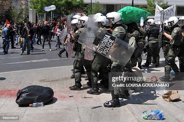 Demonstrators throw trash towards riot police outside the Finance Ministry in Athens on April 22, 2010. Greek civil servants staged on Thursday the...