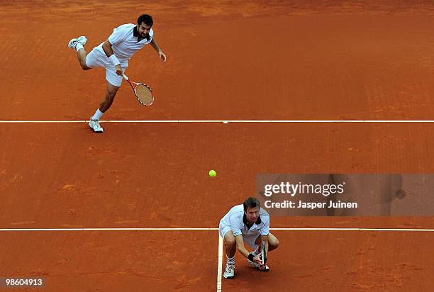 Nenad Zimonjic of Serbia serves the ball flanked by his doubles partner Daniel Nestor of Canada to Jordan Kerr of Australia and Robert Lindstedt of...