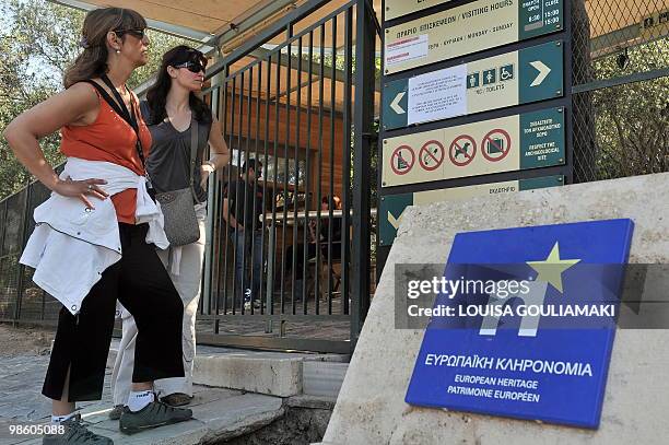Tourists read an announcement about a strike by the closed entrance to Acropolis archaeological site in Athens during a 24- hour strike on April 22,...