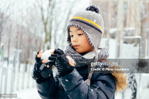 boy building a snowman - peter lourenco stock-fotos und bilder