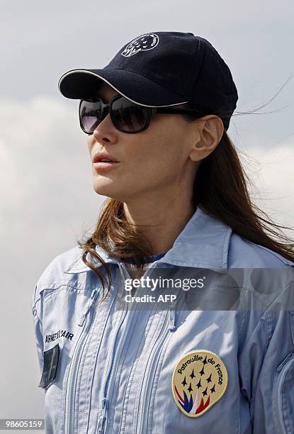 France's first lady Carla Bruni-Sarkozy patron of the French aerobatic squadron "Patrouille de France" reacts as she attends an exhibition in...