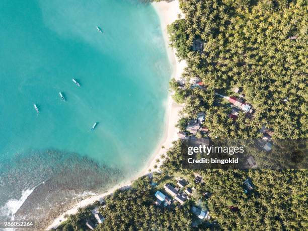 boats anchored in a small bay next to a small tropical village (aerial) - ilhas mentawai imagens e fotografias de stock