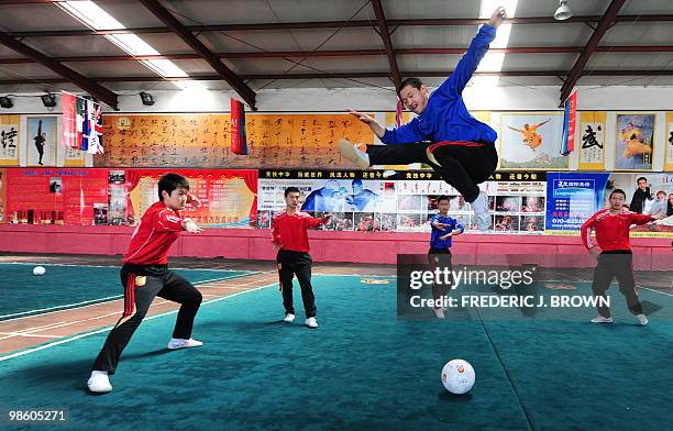 Martial arts students at a Kung fu school in the northern suburbs of Beijing practice their technique leaping over a soccer ball on April 2, 2010....