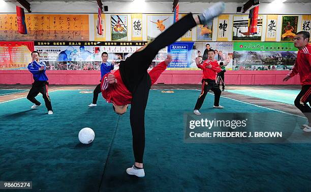 Martial arts students at a Kung fu school in the northern suburbs of Beijing practice their technique leaping over a soccer ball on April 2, 2010....