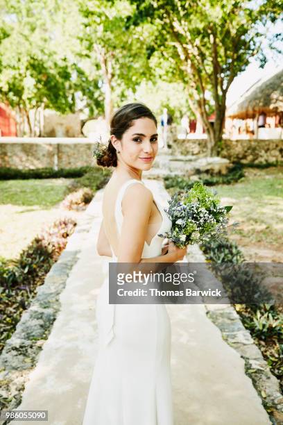 portrait of bride in wedding gown walking to outdoor ceremony at tropical resort - bride dress photos et images de collection