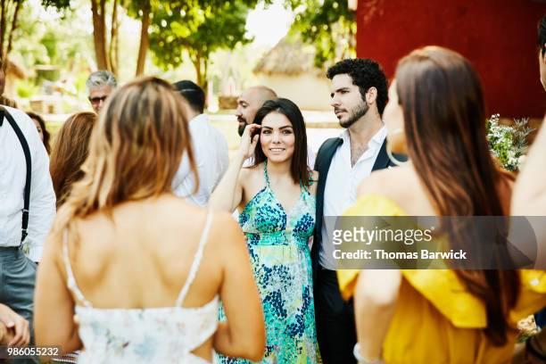 friends in discussion after outdoor wedding ceremony at tropical resort - societetsskönhet bildbanksfoton och bilder