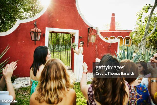 smiling bride preparing to throw bouquet during outdoor wedding reception - society beauty stock pictures, royalty-free photos & images
