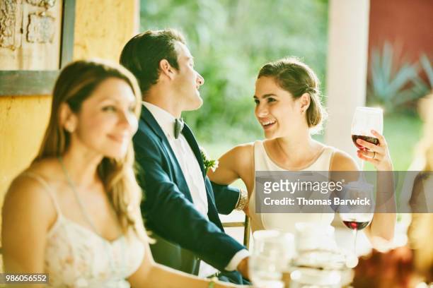 laughing bride and groom in discussion during outdoor reception dinner - societetsskönhet bildbanksfoton och bilder