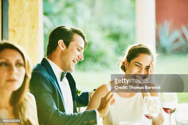 laughing bride and groom at outdoor reception dinner - wedding couple laughing photos et images de collection