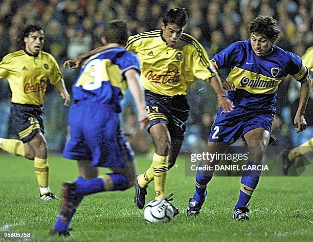 Pavel Pardo of America attempts to make a pass between Rodolfo Arruabarrena and Jorge Bermudez of Boca Juniors 31 May, 2000 while Fabian Estay looks...