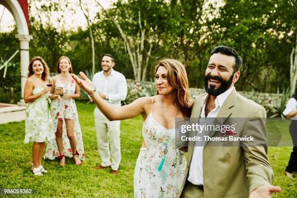laughing couple giving toast to bride and groom during outdoor wedding reception - society beauty stock pictures, royalty-free photos & images