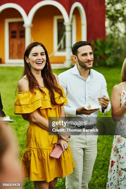 smiling and laughing friends listening to wedding toast during outdoor reception at tropical resort - wedding guests stock pictures, royalty-free photos & images