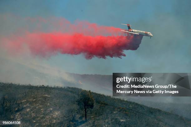 An air tanker drops fire retardant over the mountainside east of Spring Valley, Calif., Monday, June 25, 2018.