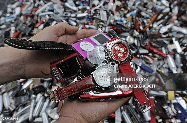 Customs officers display counterfeit MP3 players and watches destroyed by a roller at the airport in the southern German city of Munich on April 22,...