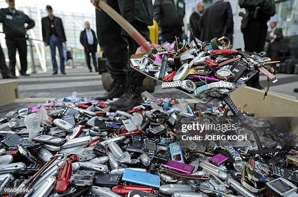 Customs officers display counterfeit MP3 players and watches destroyed by a roller at the airport in the southern German city of Munich on April 22,...