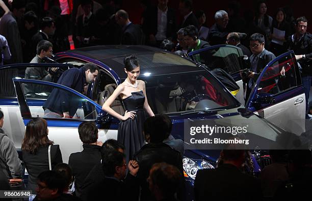 Model poses next to Daimler AG 's Maybach ultra-luxury saloon displayed during a media event unveiling the company's vehicles for the Beijing Auto...