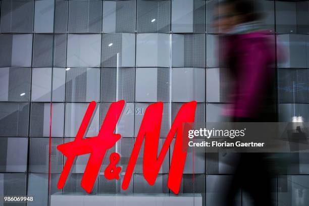 Woman walks along the logo of H&M on June 23, 2018 in Berlin, Germany.