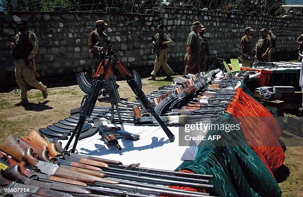 Pakistani troops stand guard infront of a cache of seized weapons which were recovered from militants in Maidan on April 22, 2010. Pakistan's...