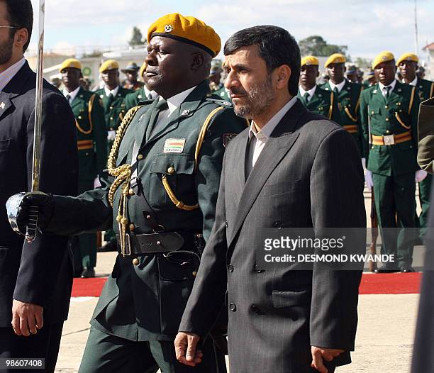 Iranian President Mahmoud Ahmadinejad inspects a guard of honor upon his arrival as he is welcome by Zimbabwean president Robert Mugabe at Harare...