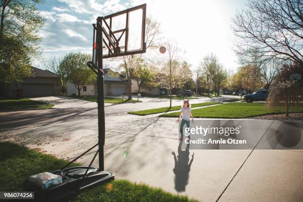 girl playing driveway basketball - shooting baskets in driveway stock pictures, royalty-free photos & images
