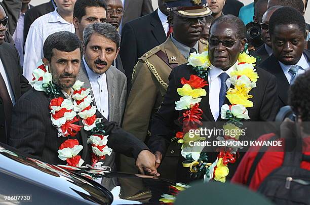 Zimbabwean president Robert Mugabe welcomes Iranian President Mahmoud Ahmadinejad at Harare Airport on April 22, 2010. Iran's President Mahmoud...