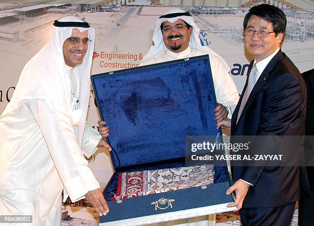 Kuwaiti Oil Minister Sheikh Ahmad Abdullah al-Sabah and the chairman of Kuwait's Oil Company Sami al-Rushaid present a souvenir to the president of...