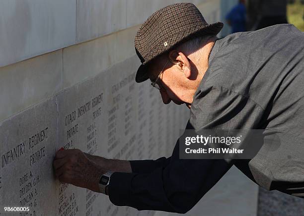 New Zealand war veteran Morris Johnstone pins a poppy next to the name of his uncle Private Roy Johnstone onto the memorial at Chunuk Bair honouring...