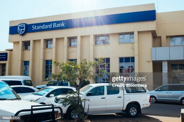 Cars sit parked outside a branch of Standard Bank Group Ltd. In Lilongwe, Malawi, on Tuesday, June 26 2018. The diversification of the...