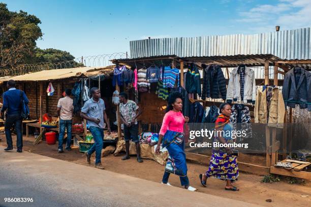 Pedestrians pass market stalls selling clothes in Lilongwe, Malawi, on Tuesday, June 26 2018. The diversification of the agriculture-reliant economy...