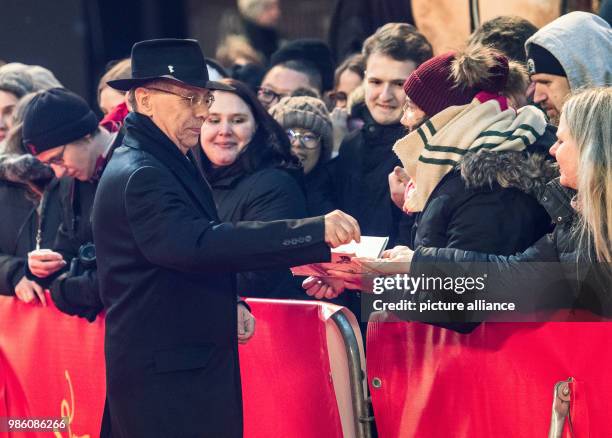 Festival director Dieter Kosslick hands out small gifts during opening night of the film 'Isle of Dogs' during the Berlinale Festival in Berlin,...