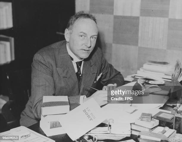 French writer Charles Braibant signs copies of his novel 'Le Roi Dort', circa 1933.