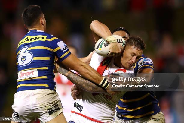 Tariq Sims of the Dragons is tackled during the round 16 NRL match between the St George Illawarra Dragons and the Parramatta Eels at WIN Stadium on...