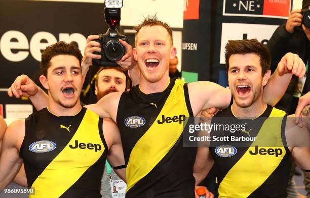 Jason Castagna of the Tigers, Jack Riewoldt of the Tigers and Trent Cotchin of the Tigers sing the song in the rooms after winning the round 15 AFL...
