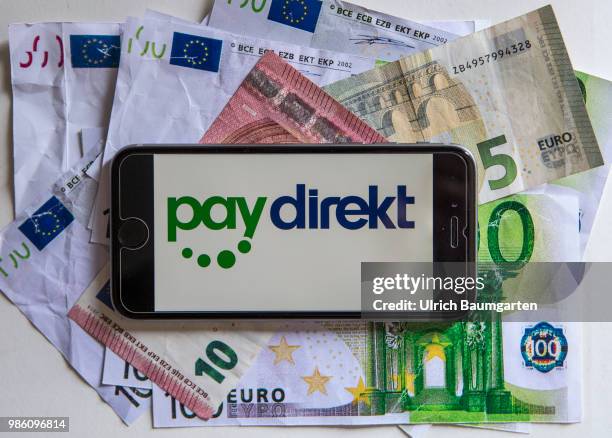 Symbol photo on the topic pay with the smartphone. The picture shows the paydirekt logo on a smartphone display. The smartphone lies on euro...