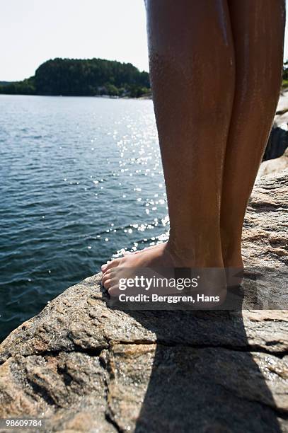 child standing on a rock by the sea, sweden. - tween heels stock pictures, royalty-free photos & images