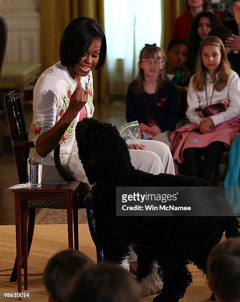 First lady Michelle Obama tries to quiet the family dog Bo as she speaks to children in the East Room of the White House April 22, 2010 in...