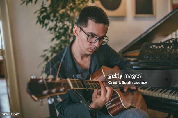 young man playing guitar - soloist stock pictures, royalty-free photos & images
