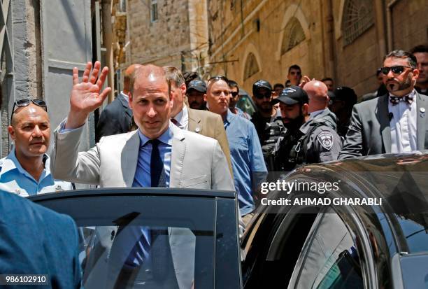 Britain's Prince William waves as he walks in a street of Jerusalem's Old City after he visited the Church of the Holy Sepulchre on June 28, 2018. -...