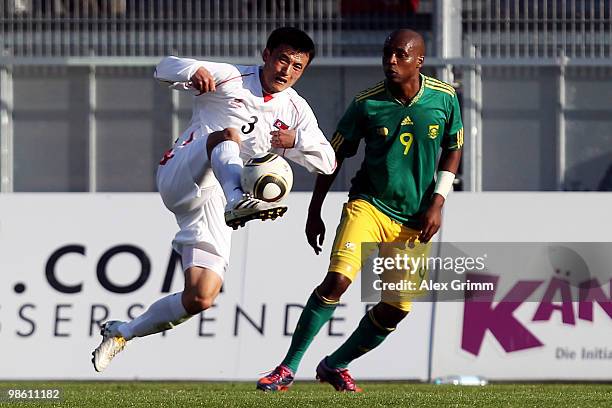 Ri Jun Il of North Korea is challenged by Katlego Mphela of South Africa during the international friendly match between South Africa and North Korea...