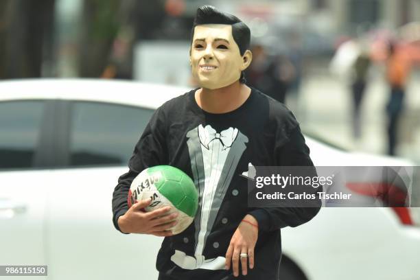 Man dressed up as current Mexican President Enrique Pena Nieto of The Mafia of Power team holds a ball during the protest match between Mafia del...