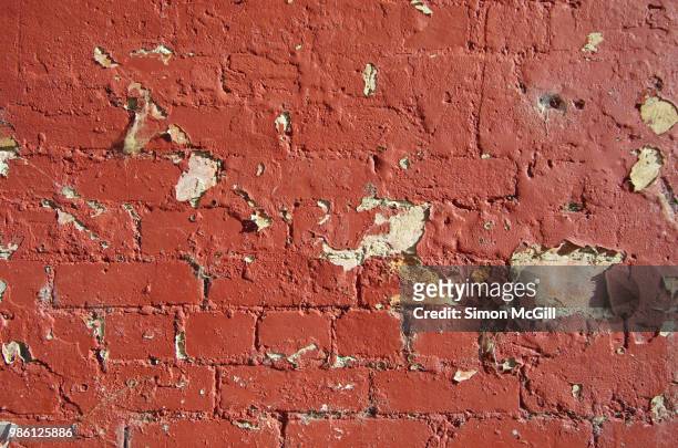 red paint peeling off a brick exterior wall - peeling off bildbanksfoton och bilder