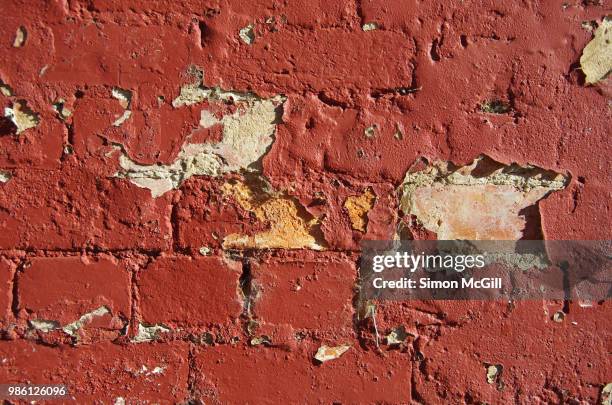 red paint peeling off a brick exterior wall - peeling off bildbanksfoton och bilder