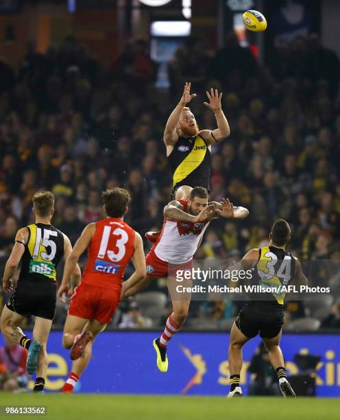 Nick Vlastuin of the Tigers takes a spectacular mark over Lance Franklin of the Swans during the 2018 AFL round15 match between the Richmond Tigers...