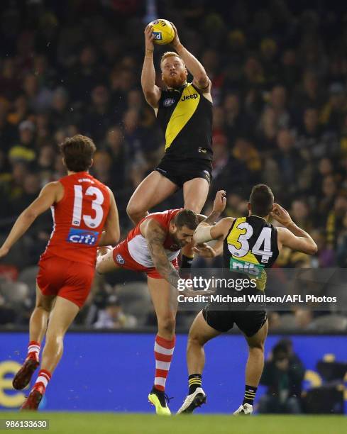 Nick Vlastuin of the Tigers takes a spectacular mark over Lance Franklin of the Swans during the 2018 AFL round15 match between the Richmond Tigers...