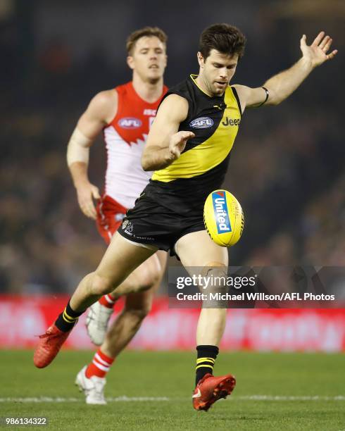 Trent Cotchin of the Tigers kicks the ball during the 2018 AFL round15 match between the Richmond Tigers and the Sydney Swans at Etihad Stadium on...