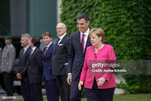 German Chancellor Angela Merkel and Spanish Prime Minister Pedro Sanchez prepare to review a guard of honor at the German Chancellory on June 26,...
