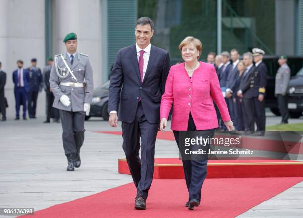 German Chancellor Angela Merkel welcomes the Spanish Prime Minister Pedro Sanchez with a guard of honor during the official ceremony in the courtyard...