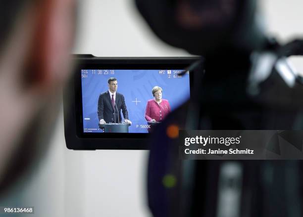 German Chancellor Angela Merkel and Spanish Prime Minister Pedro Sanchez are pictured in a camera screen during a news conference after their meeting...